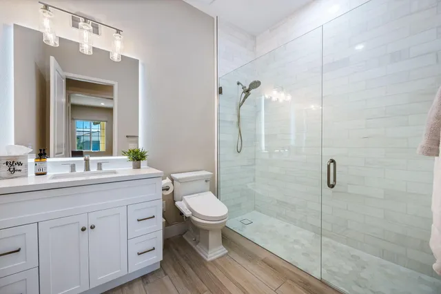 a bathroom with a sink a toilet and shower