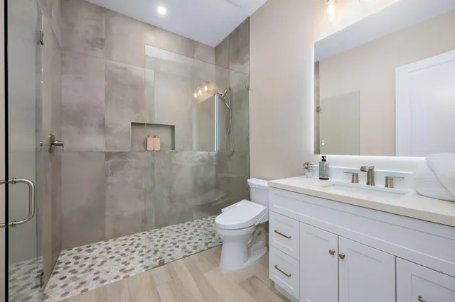 a bathroom with a sink a toilet and shower