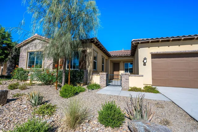 a front view of a house with a garden and yard