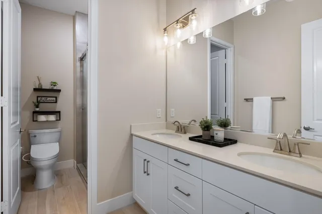 a bathroom with a granite countertop sink a toilet and a mirror