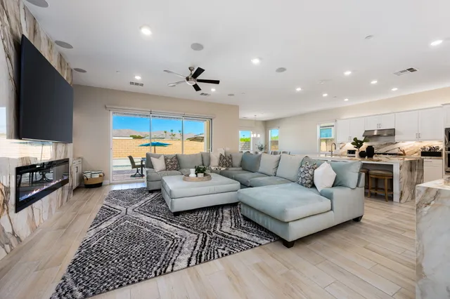 a living room with furniture a flat screen tv and kitchen view