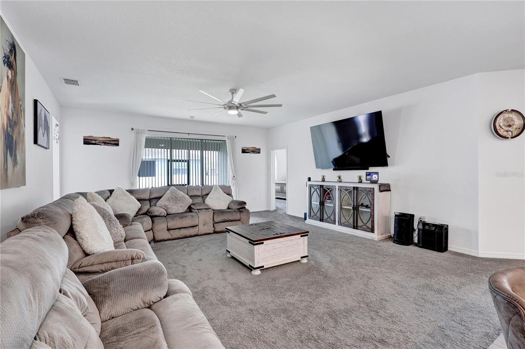 7185 Southwest 63rd Street Ocala, FL 34474 - Photo 11 of 31 a living room with furniture and a flat screen tv