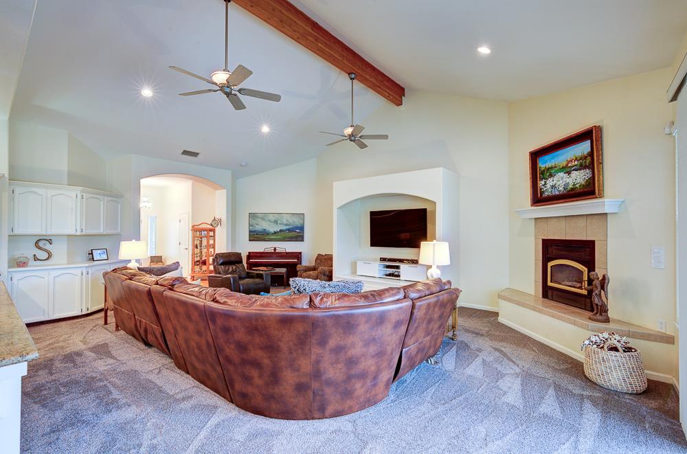 17465 Monreal Road Madera, CA 93636 - Photo 21 of 59 a living room with furniture a fireplace and a flat screen tv