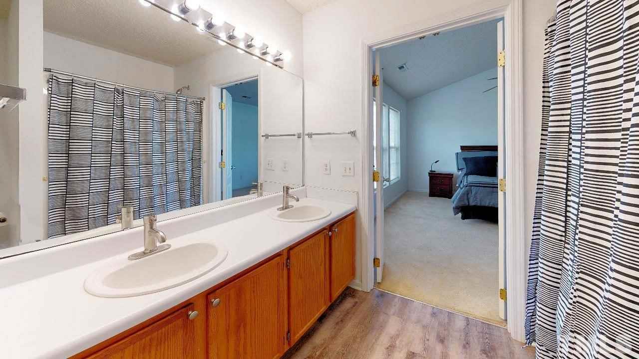 2901 Tuckland Drive Raleigh, NC 27610 - Photo 19 of 28 a en suite bathroom with a double vanity sink a mirror and a shower