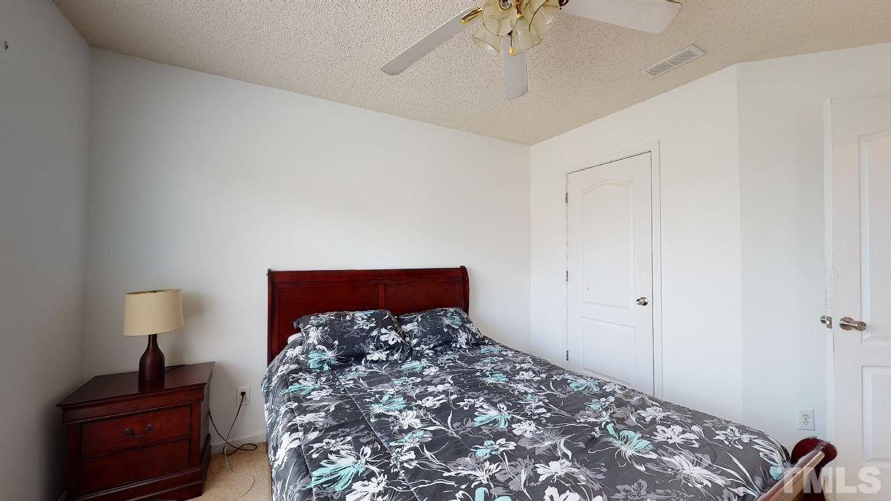2901 Tuckland Drive Raleigh, NC 27610 - Photo 21 of 28 a bed room with a bed and a lamp