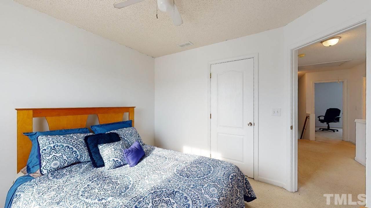 2901 Tuckland Drive Raleigh, NC 27610 - Photo 22 of 28 a bedroom with a large bed and a chandelier