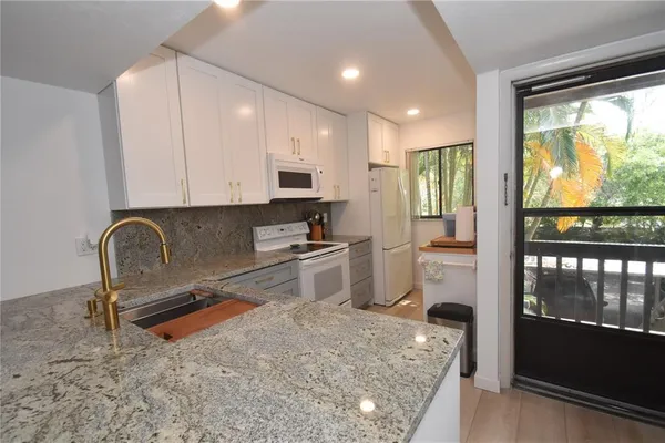 a kitchen with stainless steel appliances granite countertop a stove a sink and a refrigerator