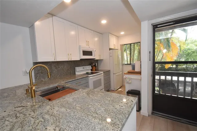 a kitchen with stainless steel appliances granite countertop a stove a sink and a refrigerator