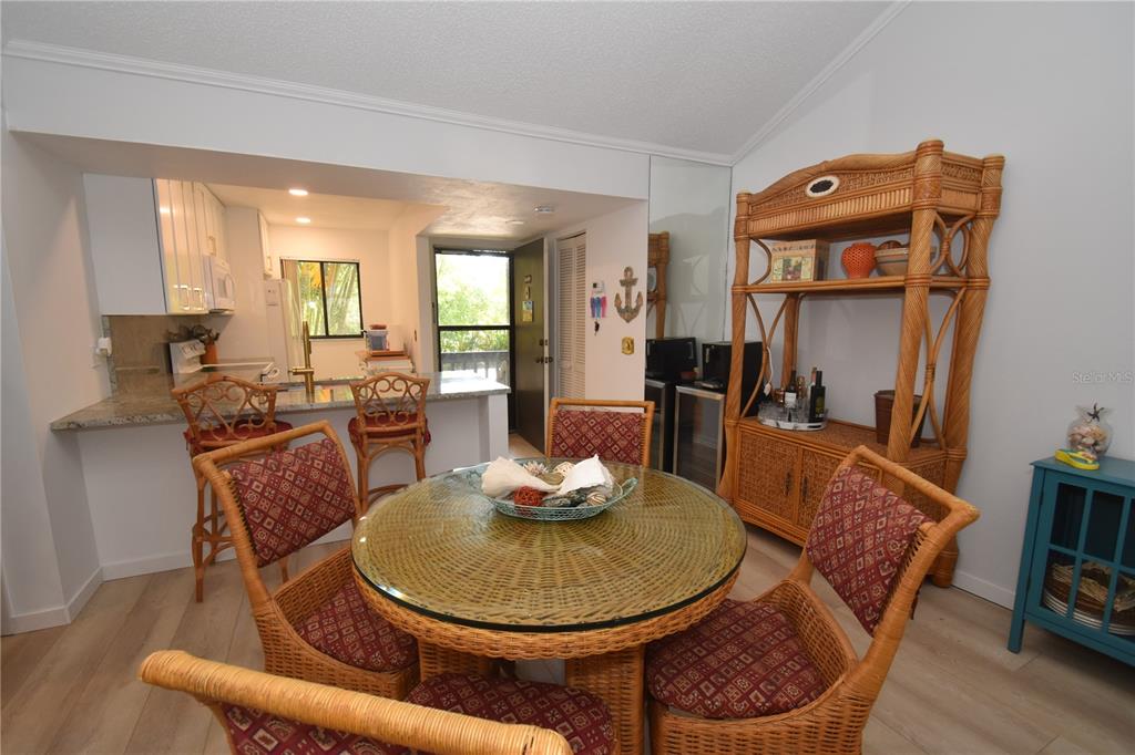 1720 Glenhouse Drive, Unit GL429 Sarasota, FL 34231 - Photo 5 of 34 a dining room with furniture and wooden floor