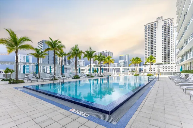 a swimming pool with outdoor seating and city view
