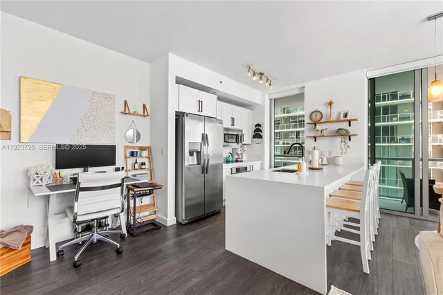 a kitchen with stainless steel appliances a refrigerator and wooden floor
