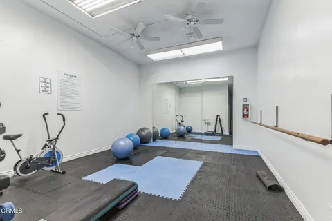 a living room with furniture gym equipment and a chandelier