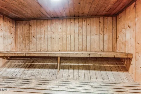 a view of a utility room with dryer and carpet