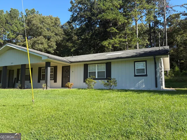 a view of a house with a yard and sitting area