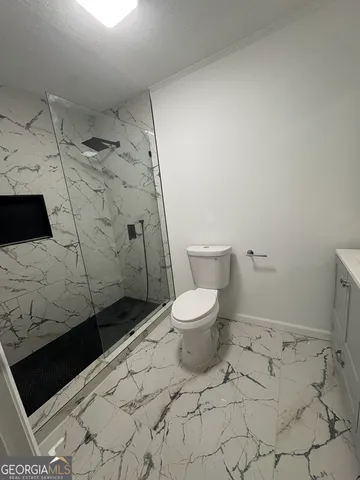 a bathroom with a toilet and a shower