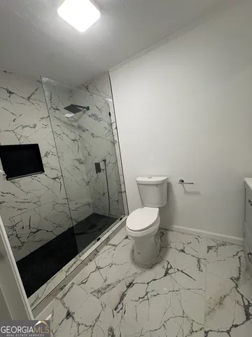 a bathroom with a toilet and a shower