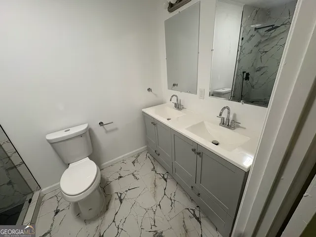 a bathroom with a sink a toilet and a mirror