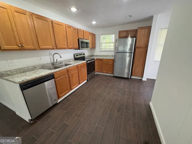 a kitchen with a sink a refrigerator freezer a microwave and cabinets