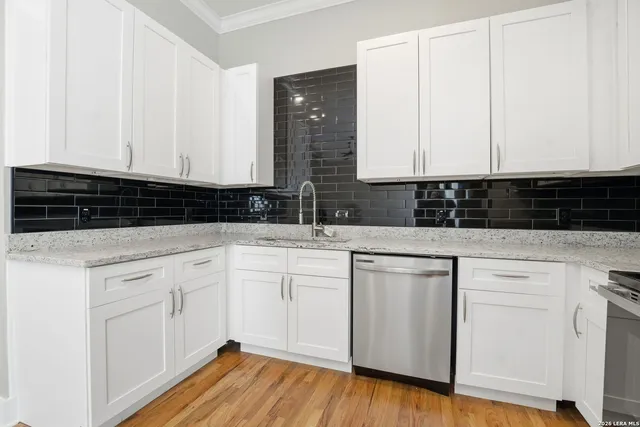 a kitchen with granite countertop white cabinets and white appliances