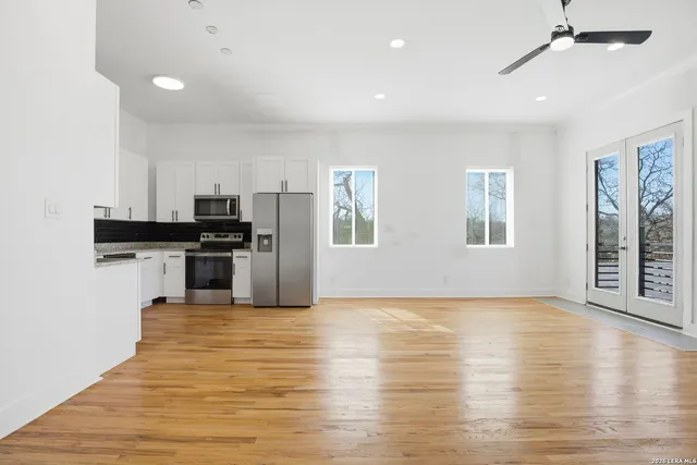 a view of kitchen with granite countertop cabinets and refrigerator