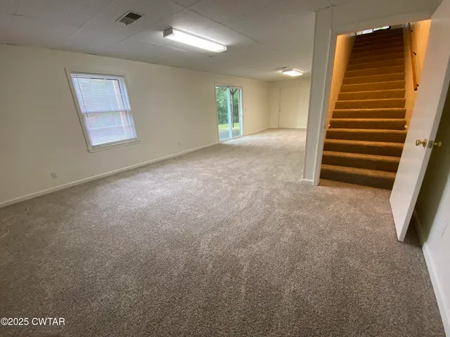 an empty room with windows and stairs