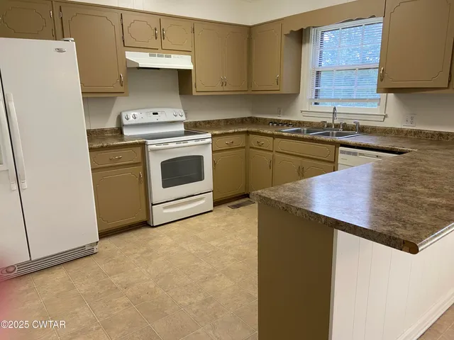 a kitchen with a stove sink and cabinets
