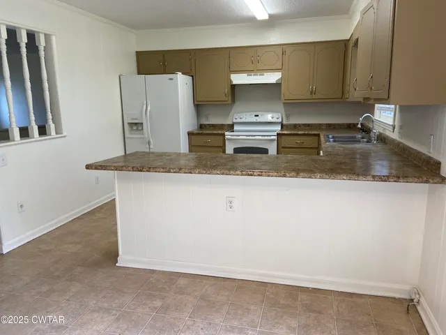 a kitchen with stainless steel appliances granite countertop a sink a stove a refrigerator a counter space and cabinets