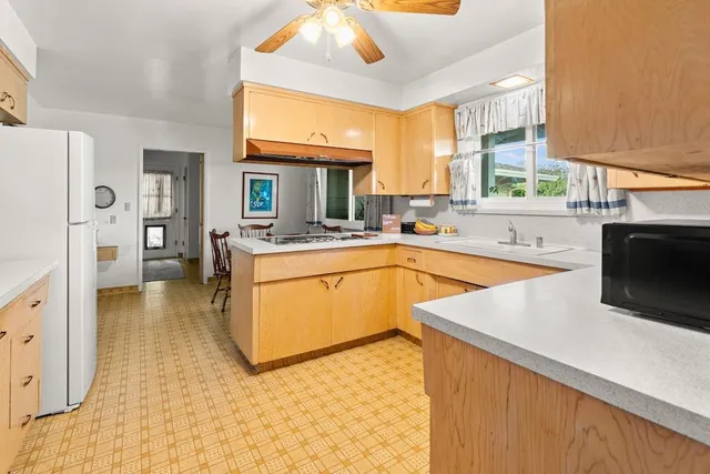 a kitchen with stainless steel appliances granite countertop a sink a stove and a refrigerator