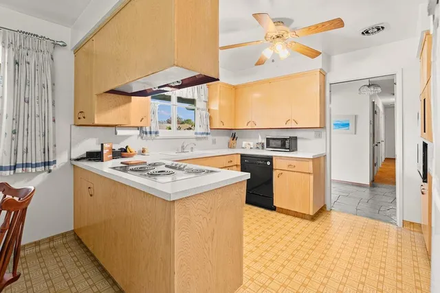 a kitchen with a stove a sink a refrigerator and a dining table