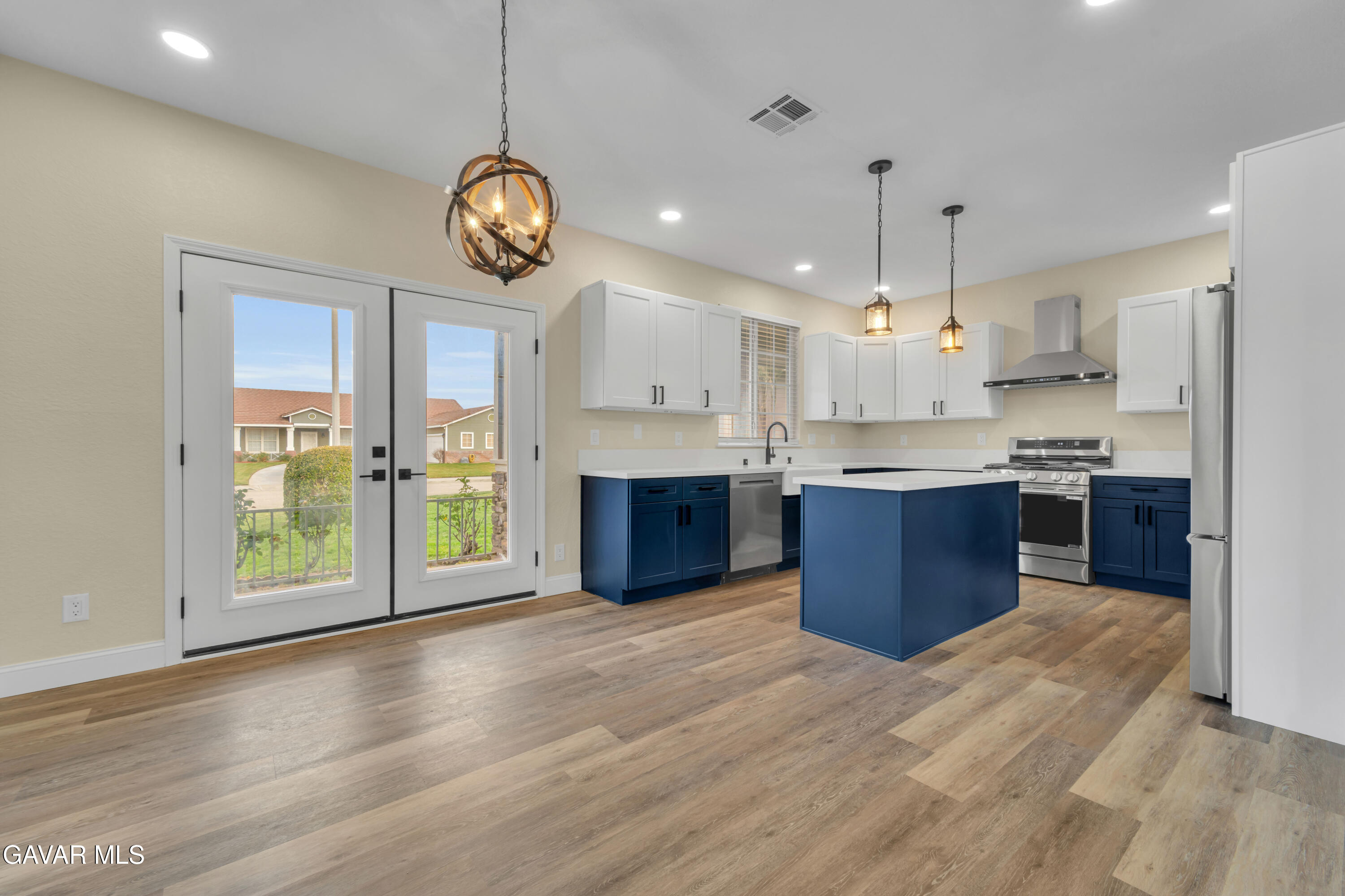 43323 Honeybee Lane Lancaster, CA 93536 - Photo 21 of 32 a large kitchen with stainless steel appliances granite countertop a stove a sink dishwasher a refrigerator and a dining table with wooden floor