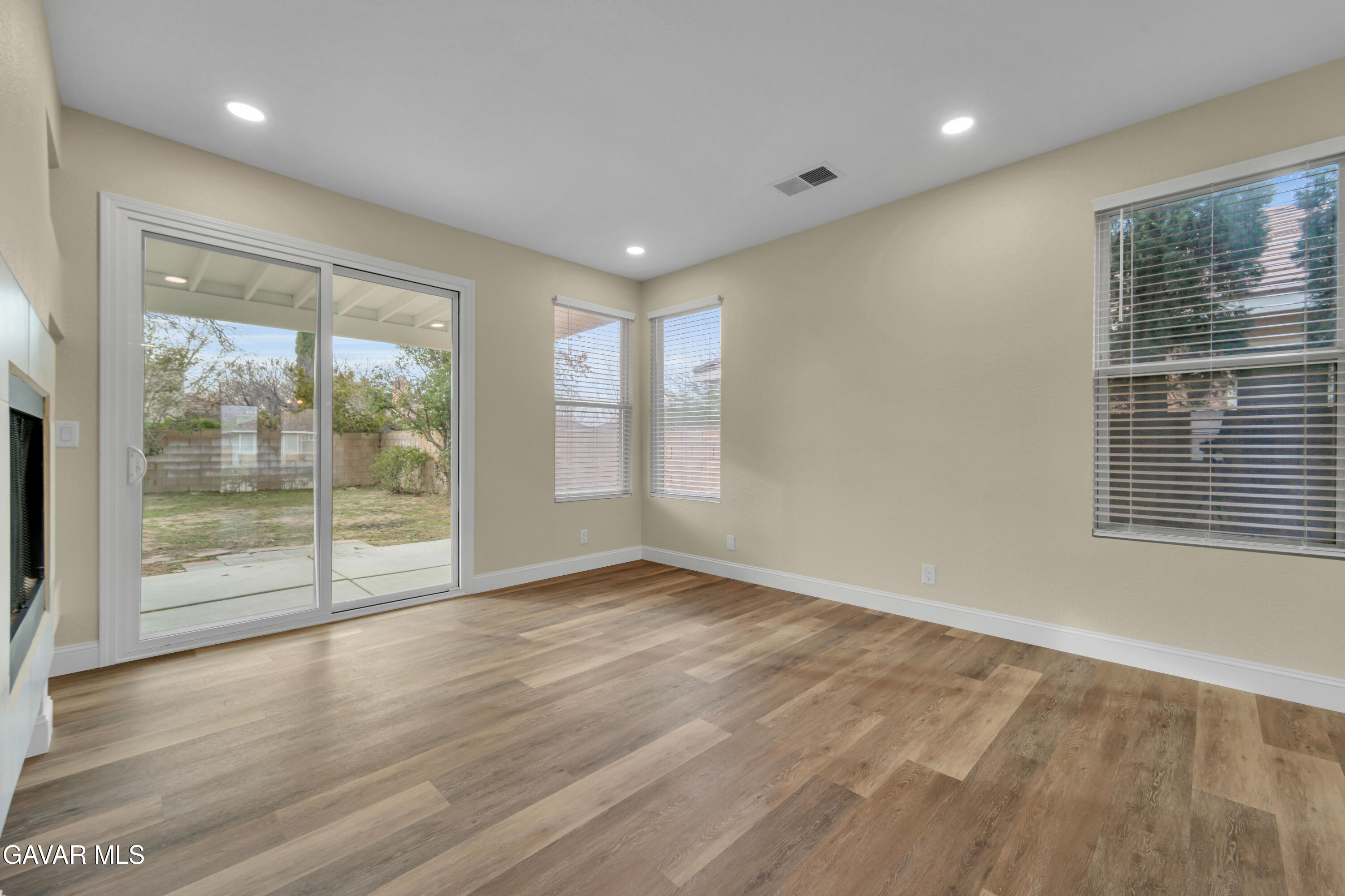 43323 Honeybee Lane Lancaster, CA 93536 - Photo 7 of 32 a view of an empty room with wooden floor and a window