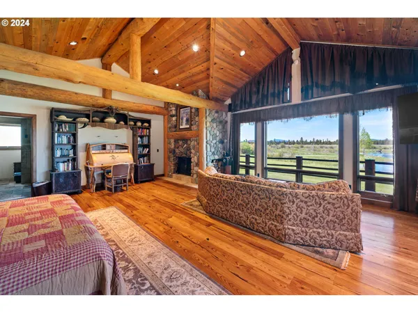 a large bedroom with a bed and wooden floor
