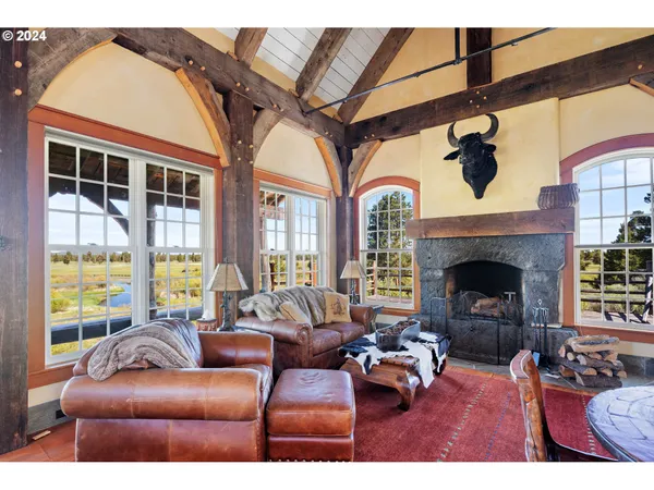 a living room with furniture fireplace and a large window