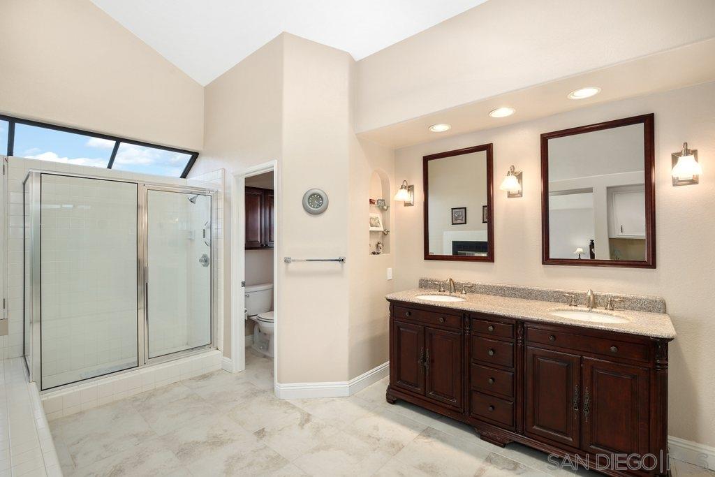 5058 Frazee Road Oceanside, CA 92057 - Photo 13 of 25 a spacious bathroom with a double vanity sink a mirror and shower
