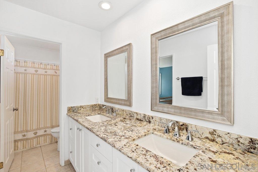 5058 Frazee Road Oceanside, CA 92057 - Photo 15 of 25 a bathroom with a granite countertop sink and a mirror