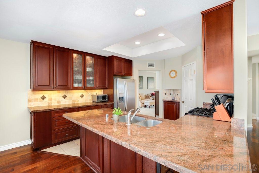 5058 Frazee Road Oceanside, CA 92057 - Photo 5 of 25 a kitchen with stainless steel appliances granite countertop a sink refrigerator and cabinets