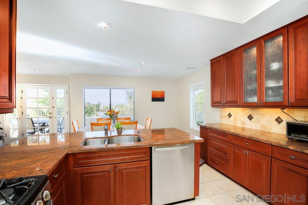 5058 Frazee Road Oceanside, CA 92057 - Photo 7 of 25 a kitchen with a sink and wooden cabinets