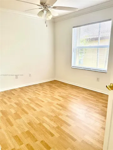 an empty room with a window and a ceiling fan