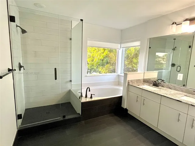 a bathroom with a tub sink and shower