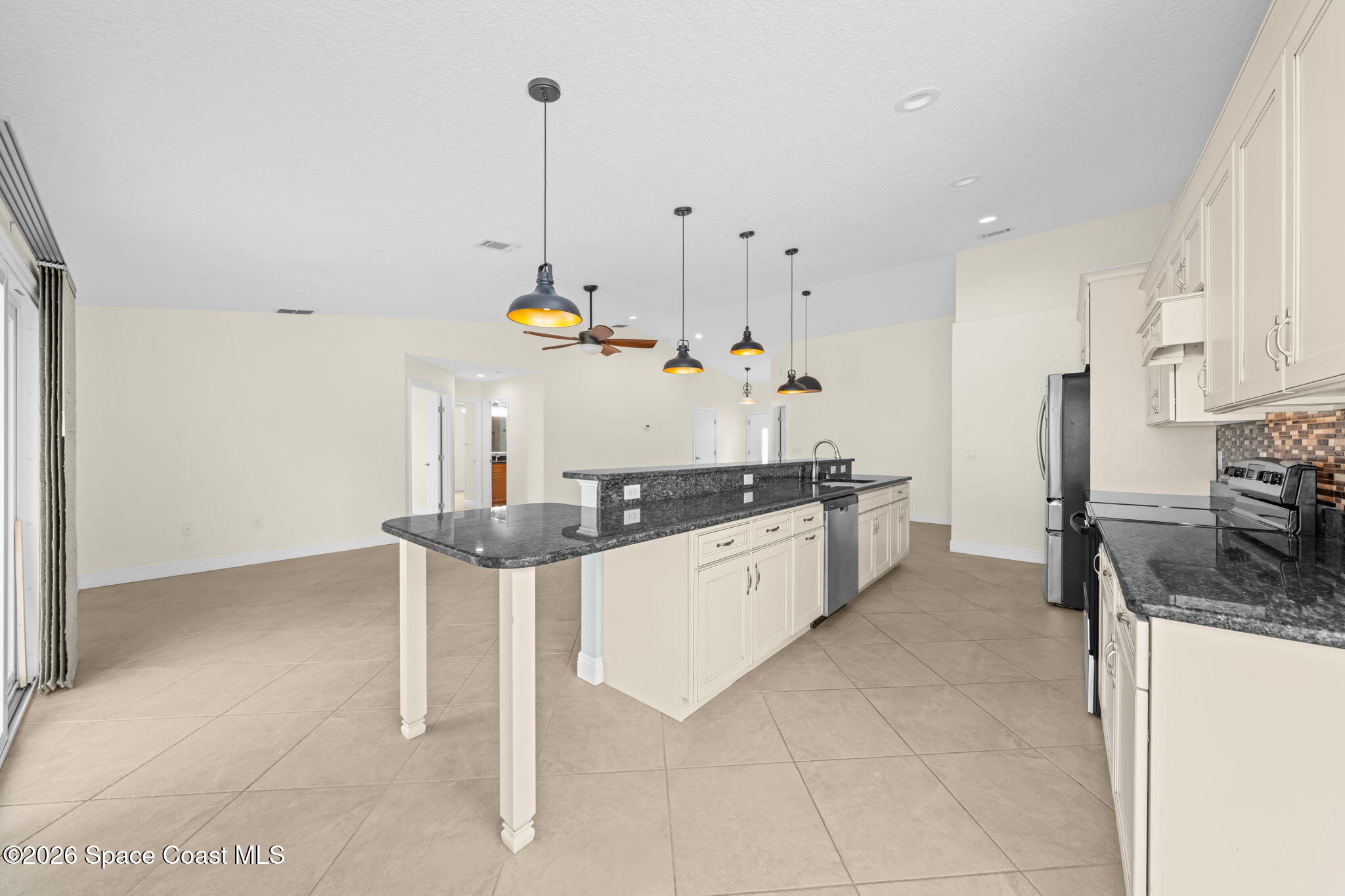 1236 Walnut Grove Way Rockledge, FL 32955 - Photo 12 of 43 a kitchen with stainless steel appliances kitchen island granite countertop a stove a sink and a refrigerator