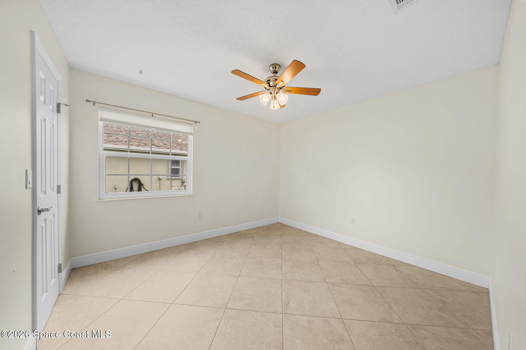 1236 Walnut Grove Way Rockledge, FL 32955 - Photo 19 of 43 an empty room with a window and a ceiling fan