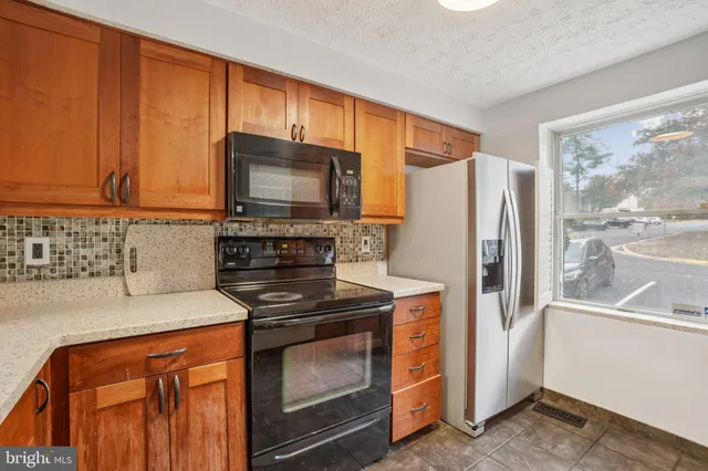 a kitchen with stainless steel appliances granite countertop a refrigerator stove and microwave