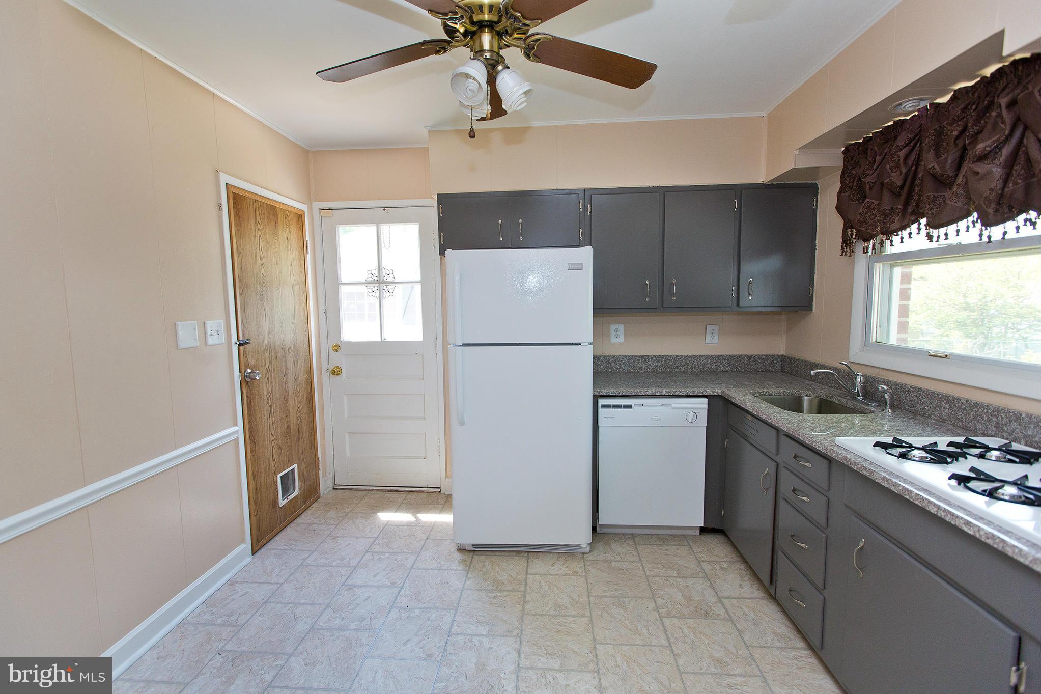 1012 Crosby Road Baltimore, MD 21228 - Photo 6 of 24 a kitchen with a refrigerator a stove top oven a sink and dishwasher