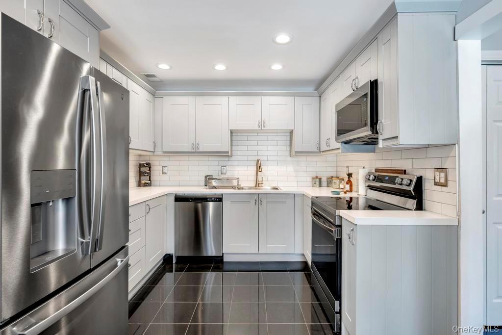 114 Birchwood Road Coram, NY 11727 - Photo 11 of 24 a kitchen with a refrigerator sink and microwave