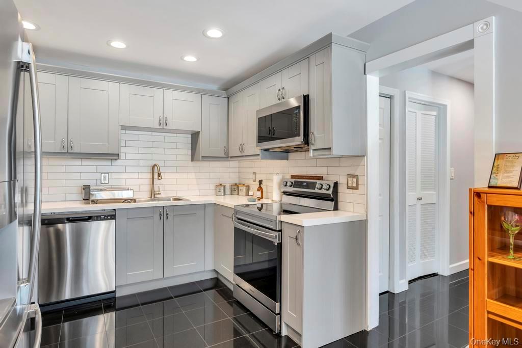 114 Birchwood Road Coram, NY 11727 - Photo 12 of 24 a kitchen with a sink stove and microwave