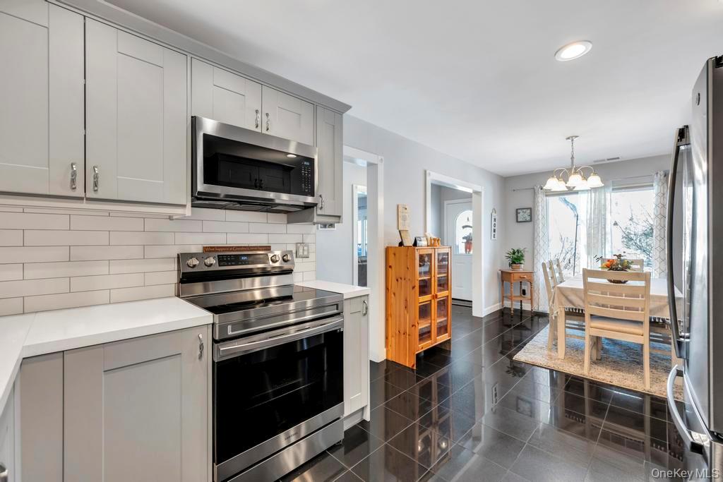 114 Birchwood Road Coram, NY 11727 - Photo 13 of 24 a kitchen with stainless steel appliances a stove microwave and refrigerator