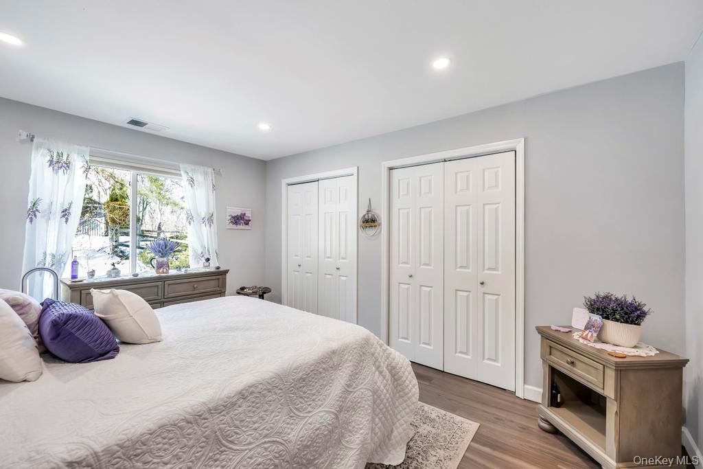 114 Birchwood Road Coram, NY 11727 - Photo 19 of 24 a bedroom with a bed and a potted plant