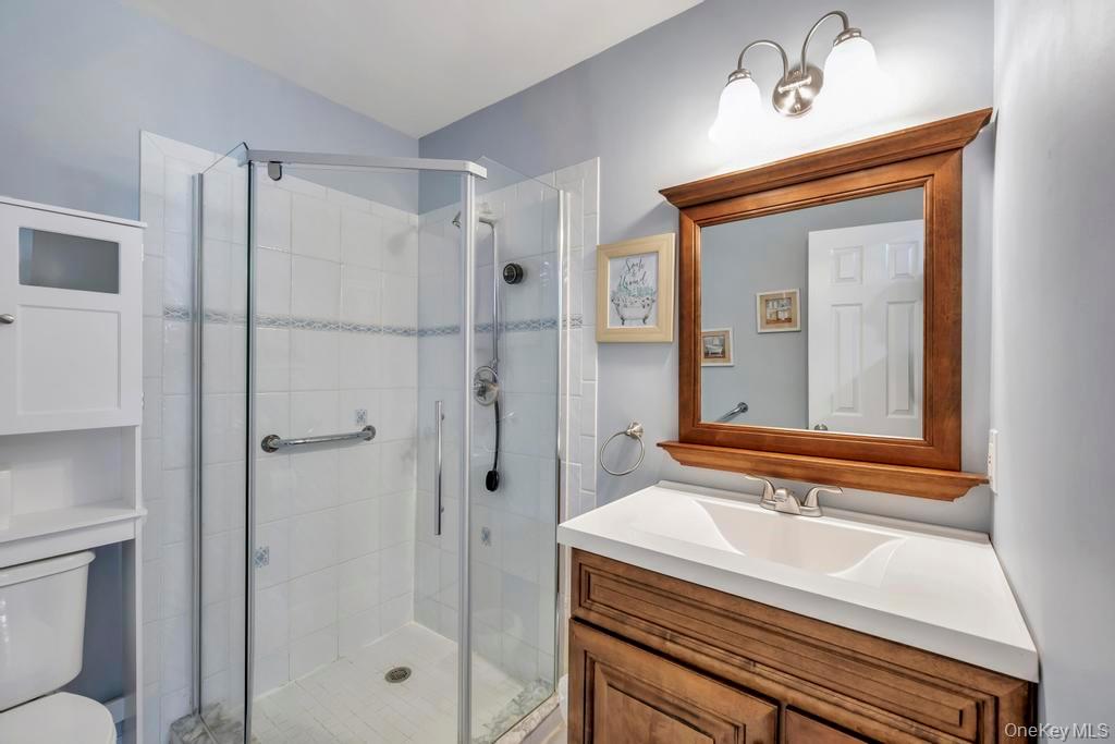 114 Birchwood Road Coram, NY 11727 - Photo 20 of 24 a bathroom with a sink a mirror and a shower