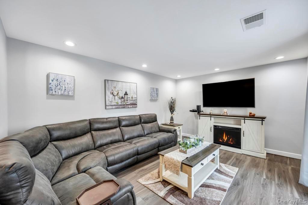 114 Birchwood Road Coram, NY 11727 - Photo 3 of 24 a living room with furniture a flat screen tv and a fireplace