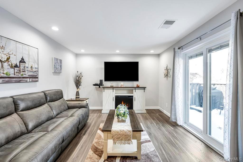 114 Birchwood Road Coram, NY 11727 - Photo 6 of 24 a living room with fireplace furniture and a flat screen tv
